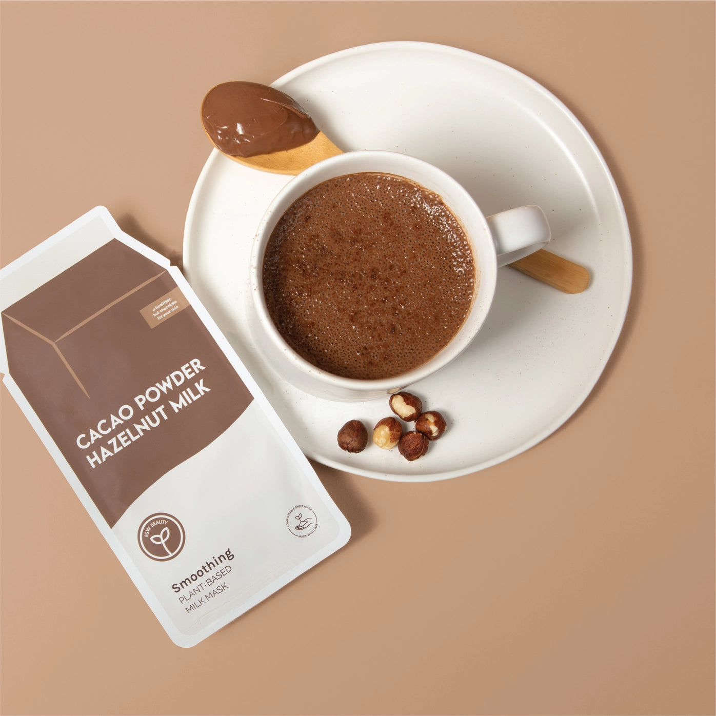 Cacao powder hazelnut milk package with a cup of hot chocolate on a beige background